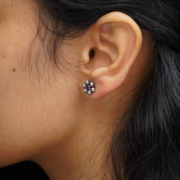 a close up of a person wearing a pair of earrings