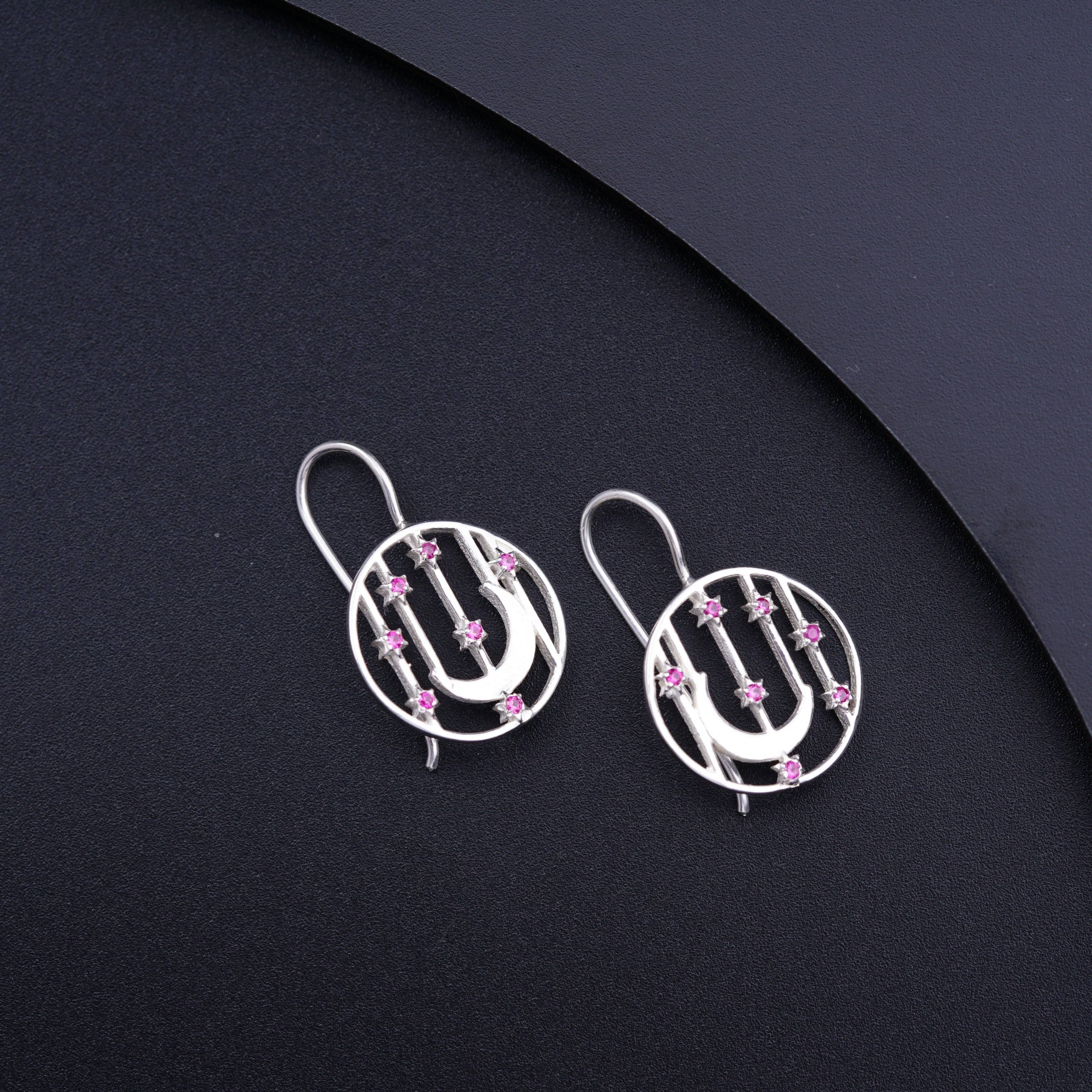 a pair of silver earrings with pink beads