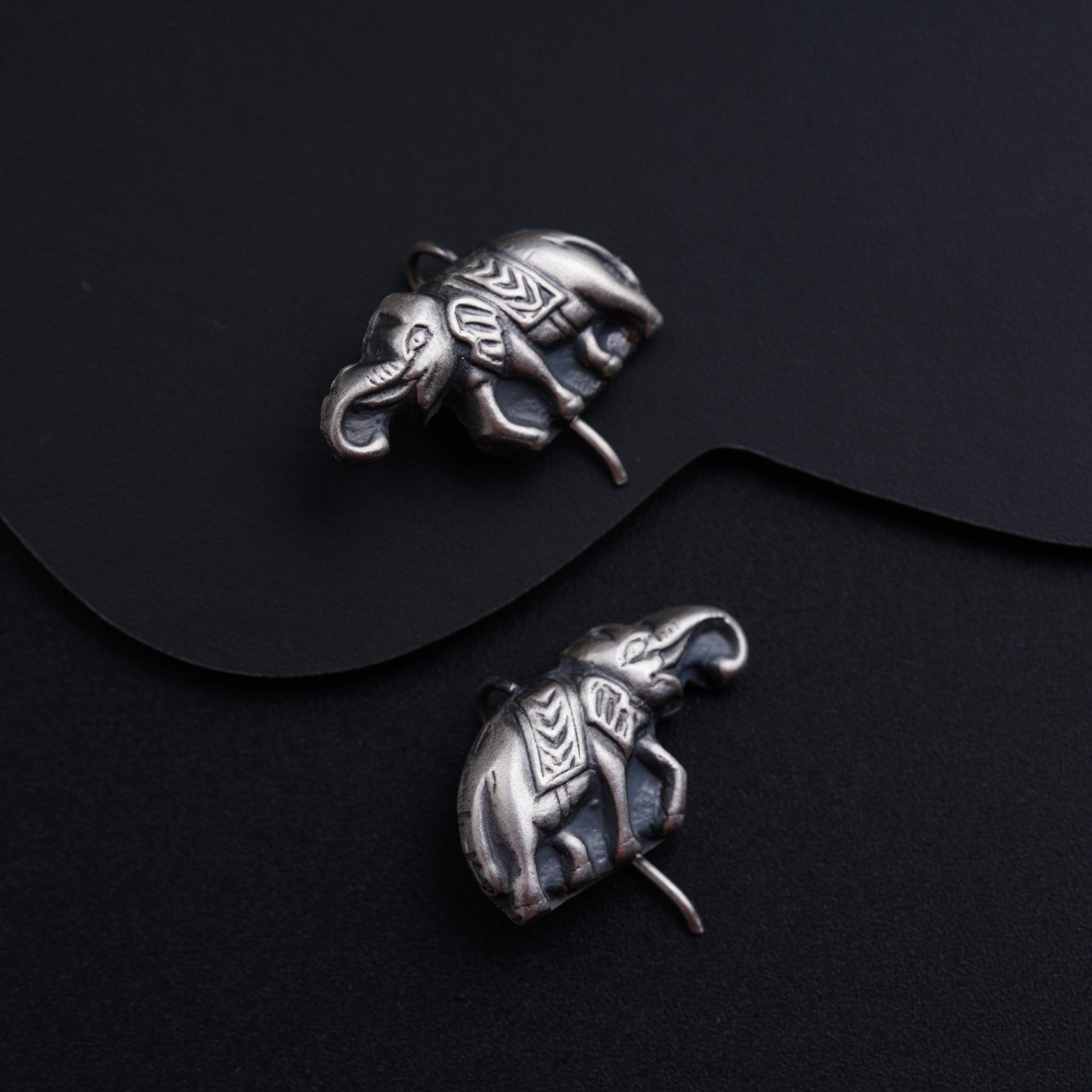 a pair of silver elephants on a black surface