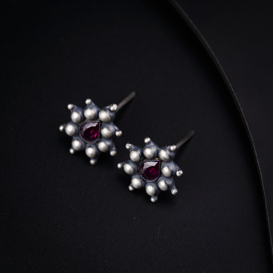 a pair of silver earrings with garnets and pearls