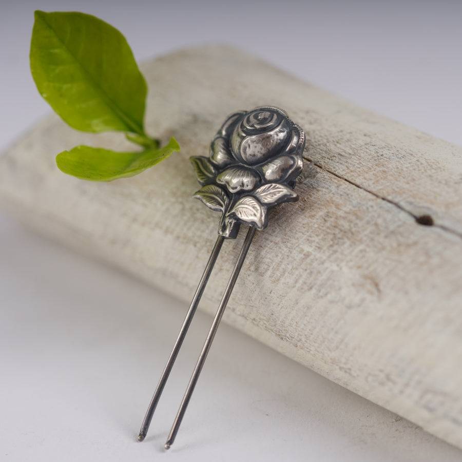 a pair of metal flowers sitting on top of a piece of wood