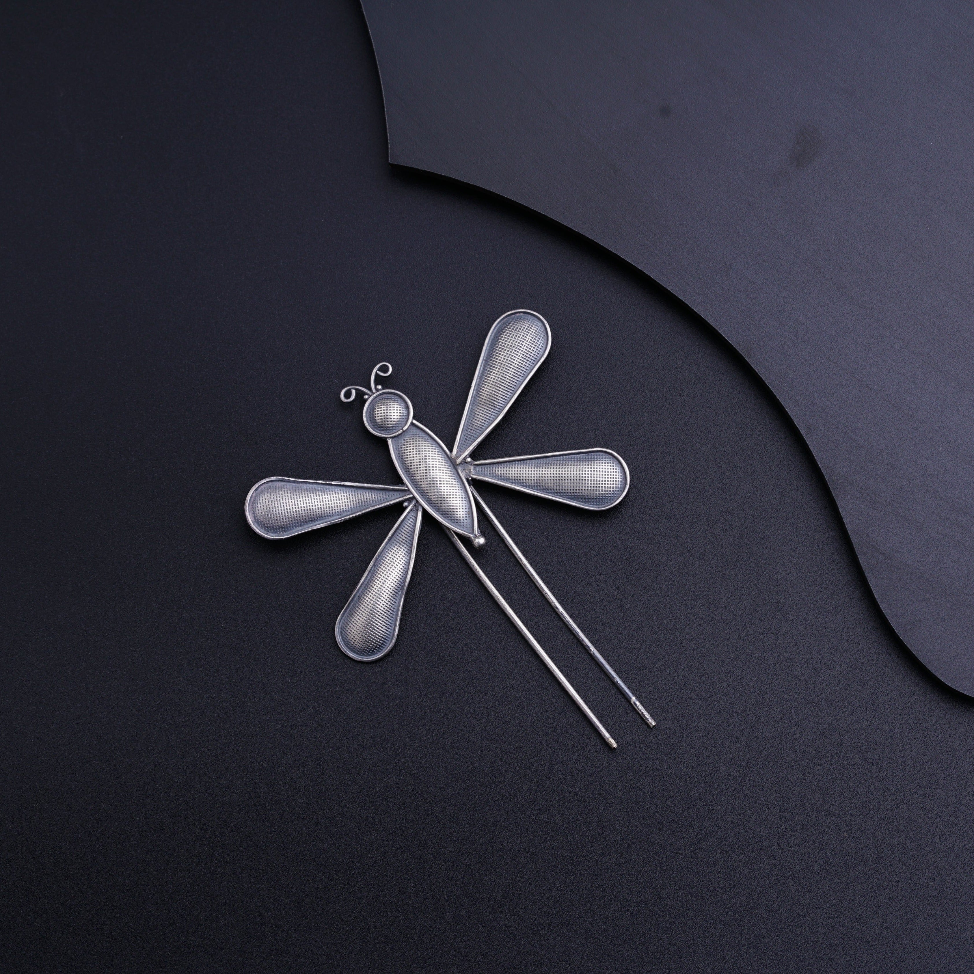 a dragonfly brooch with a pair of scissors