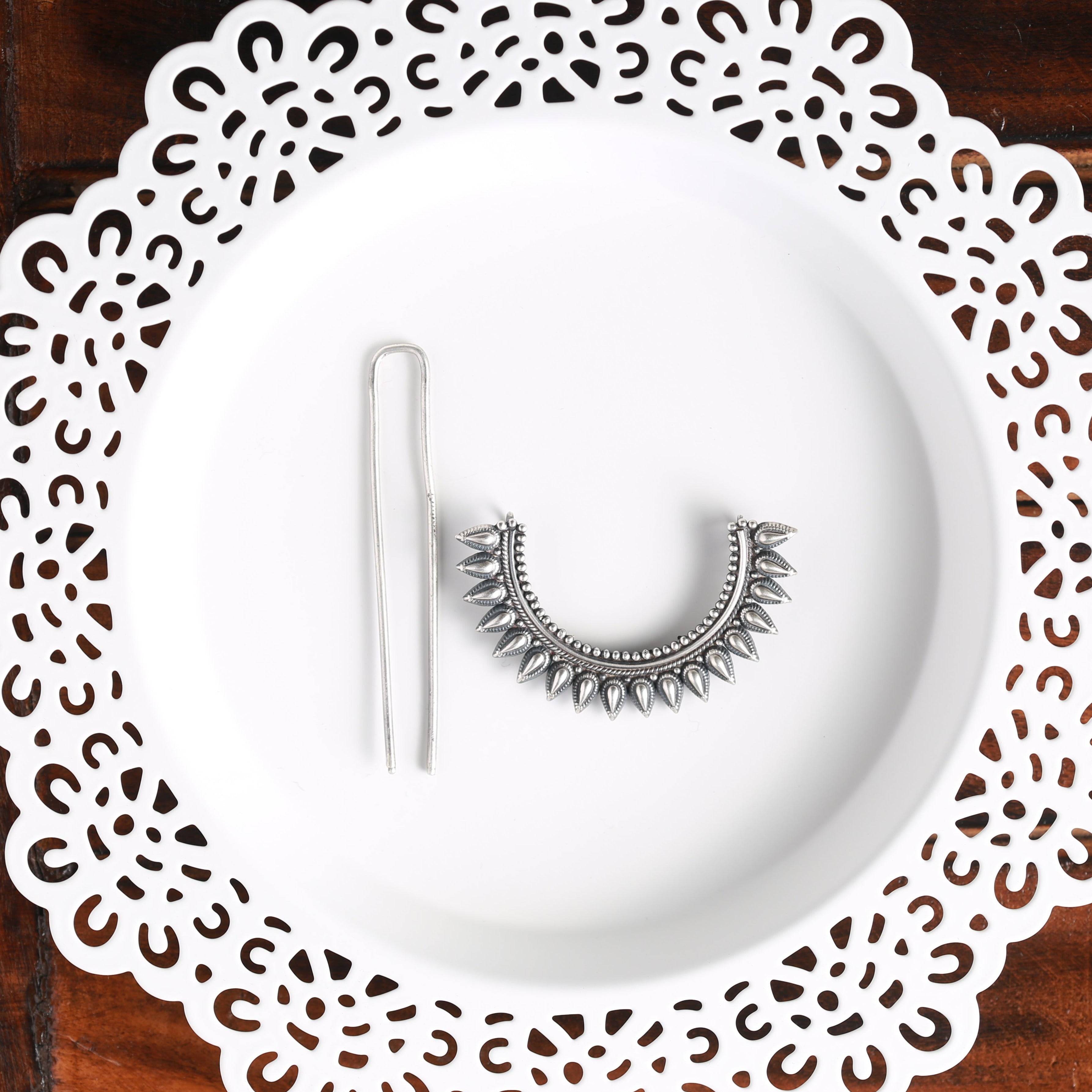 a white plate topped with a pair of earrings