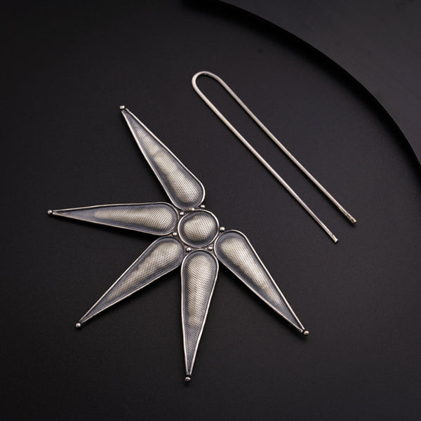 a pair of scissors and a pin on a table