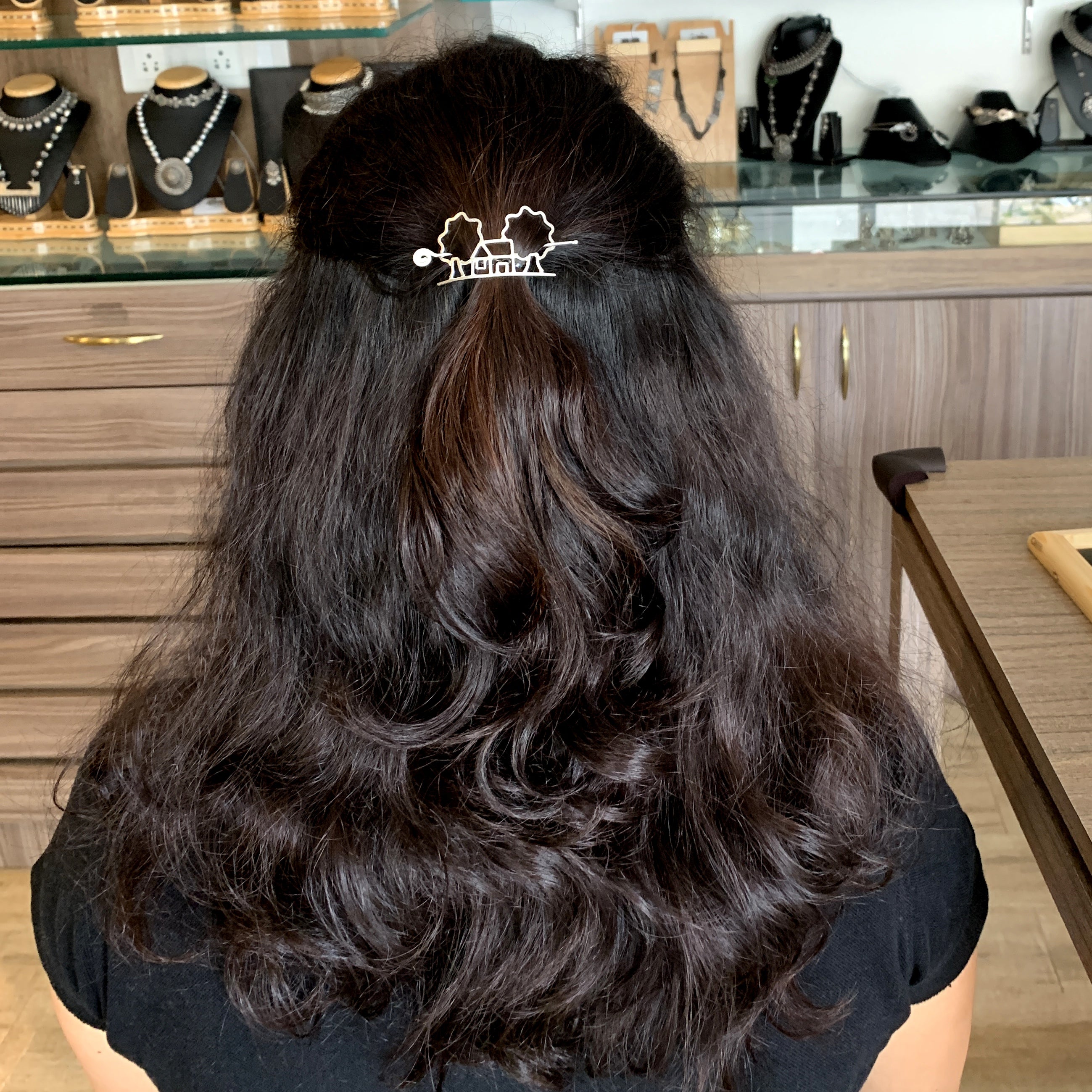 a woman sitting at a table with a hair clip in her hair
