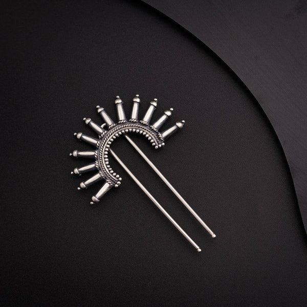 a pair of metal pins sitting on top of a black surface