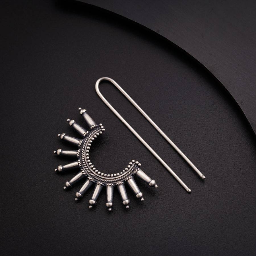 a pair of earrings and a pair of needles
