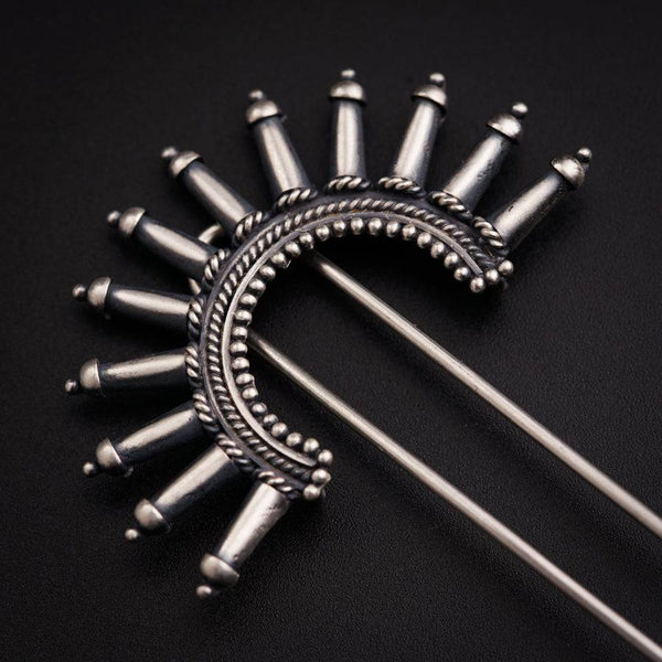 a bunch of metal pins sitting on top of a black surface