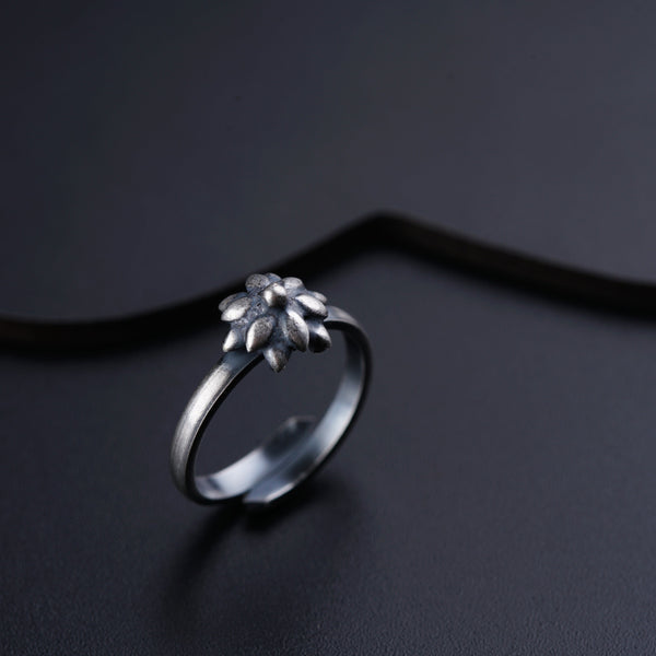 a silver ring with a flower on it