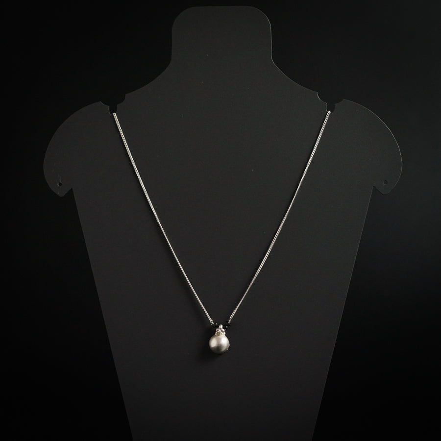 a necklace with a silver ball hanging from it