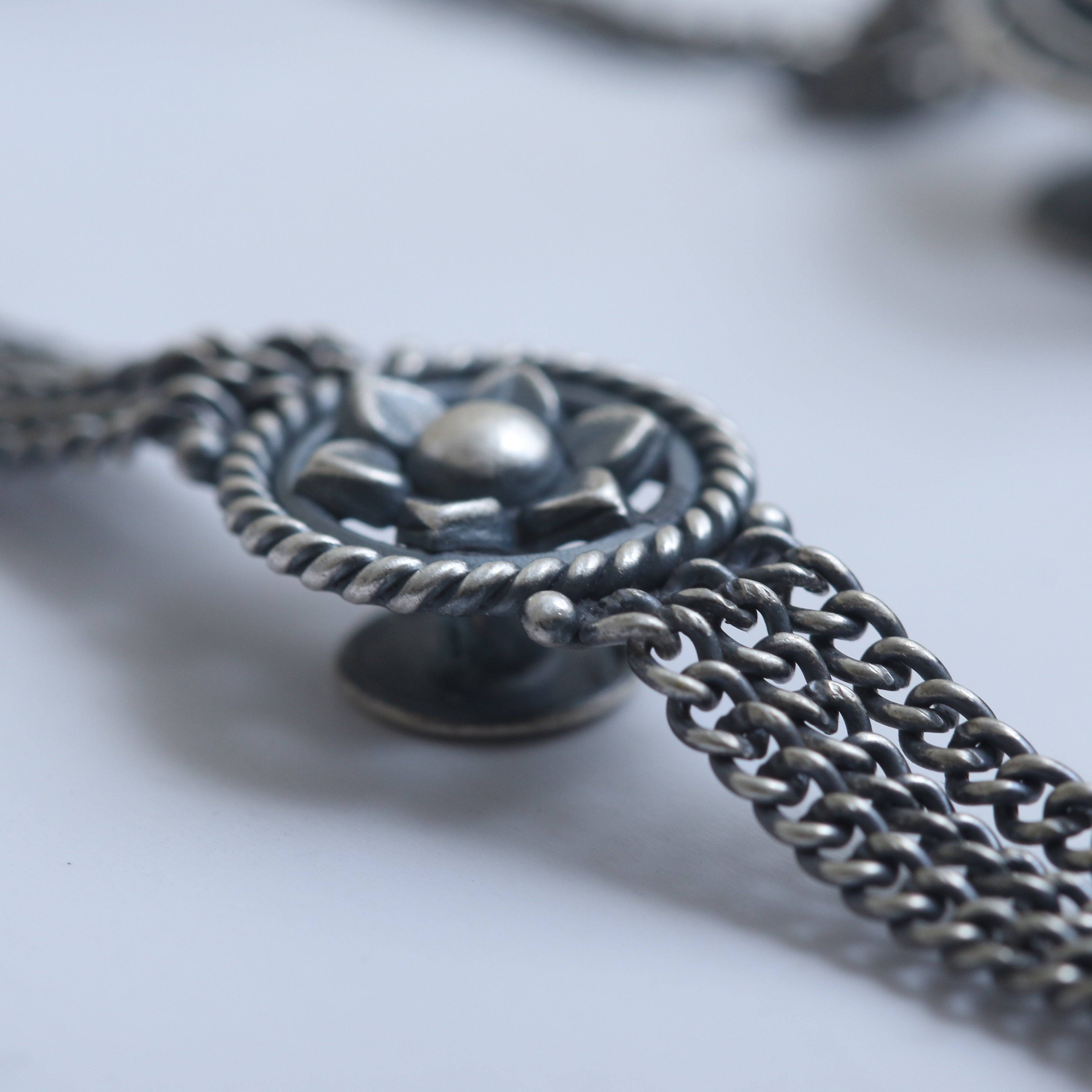 a close up of a chain with a flower on it