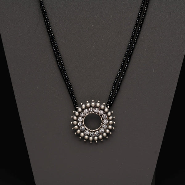 a necklace with beads and a circle pendant