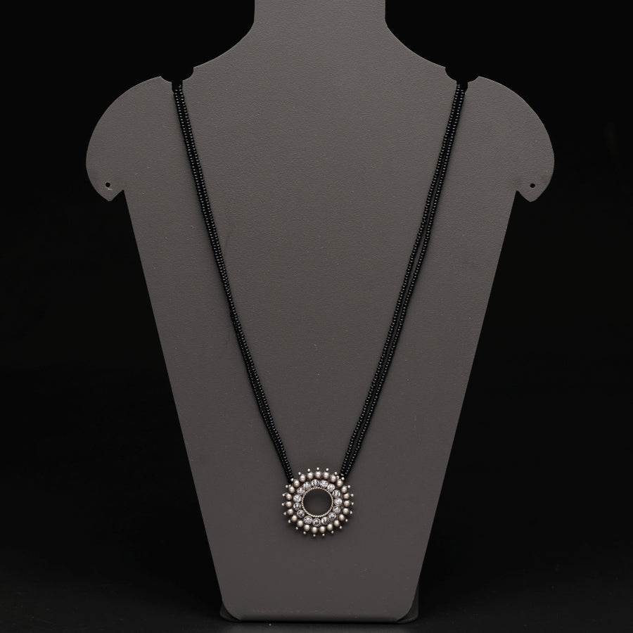 a necklace on a mannequin with a black background