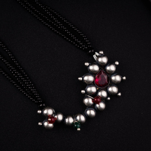 a close up of a necklace on a black surface