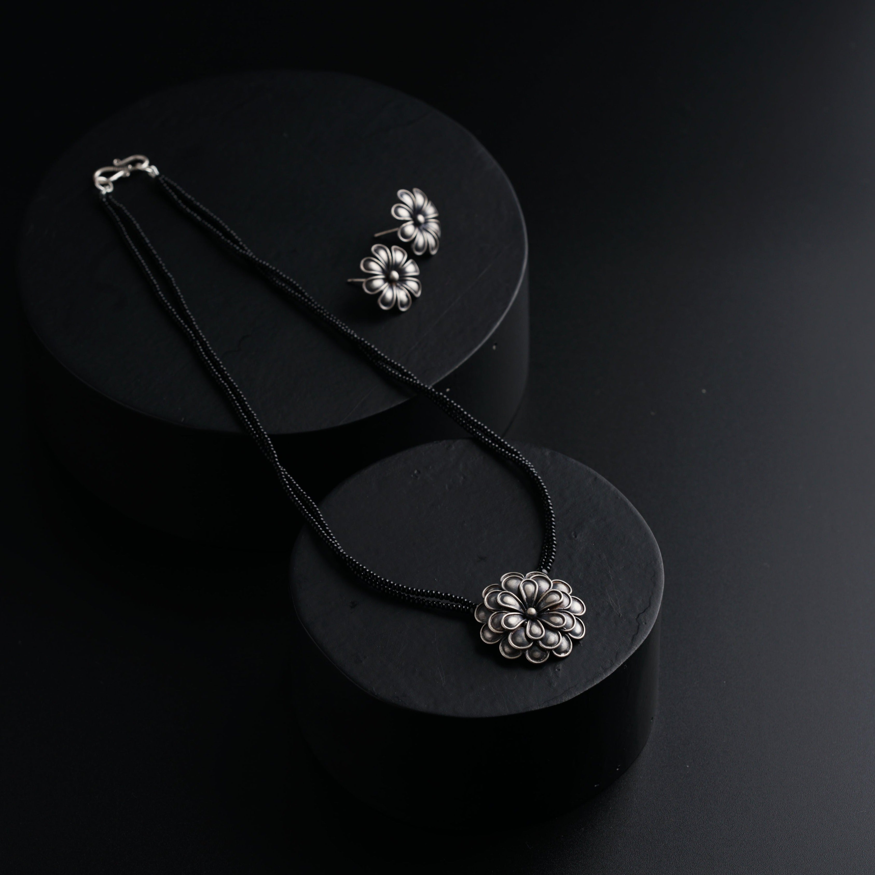 a pair of necklaces sitting on top of a black plate