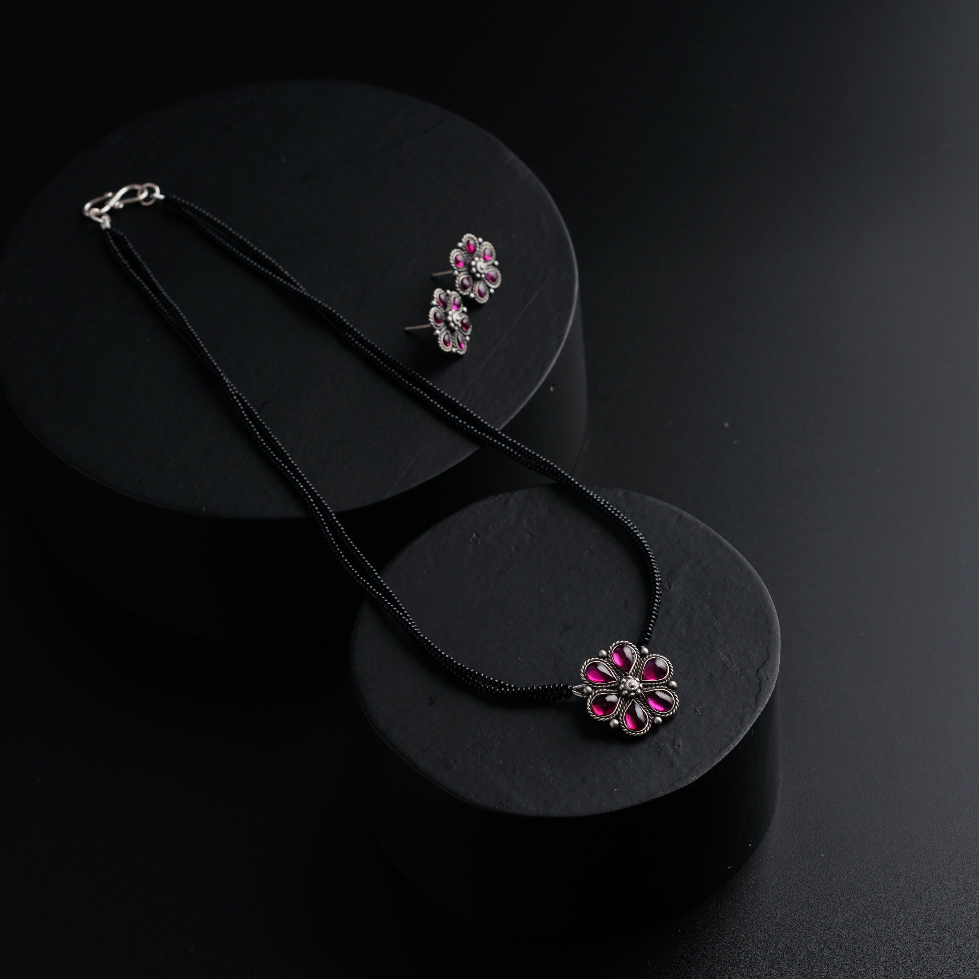 a pair of necklaces sitting on top of a black box