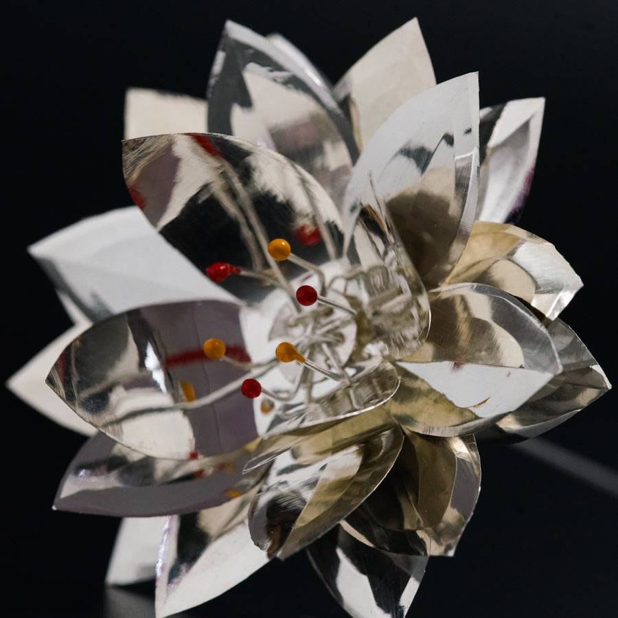 a close up of a metal flower on a black surface