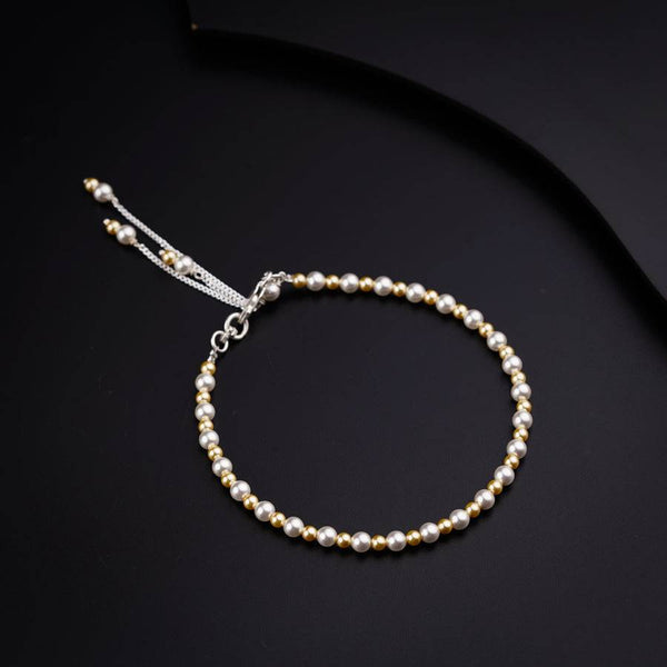 a bracelet with pearls on a black background