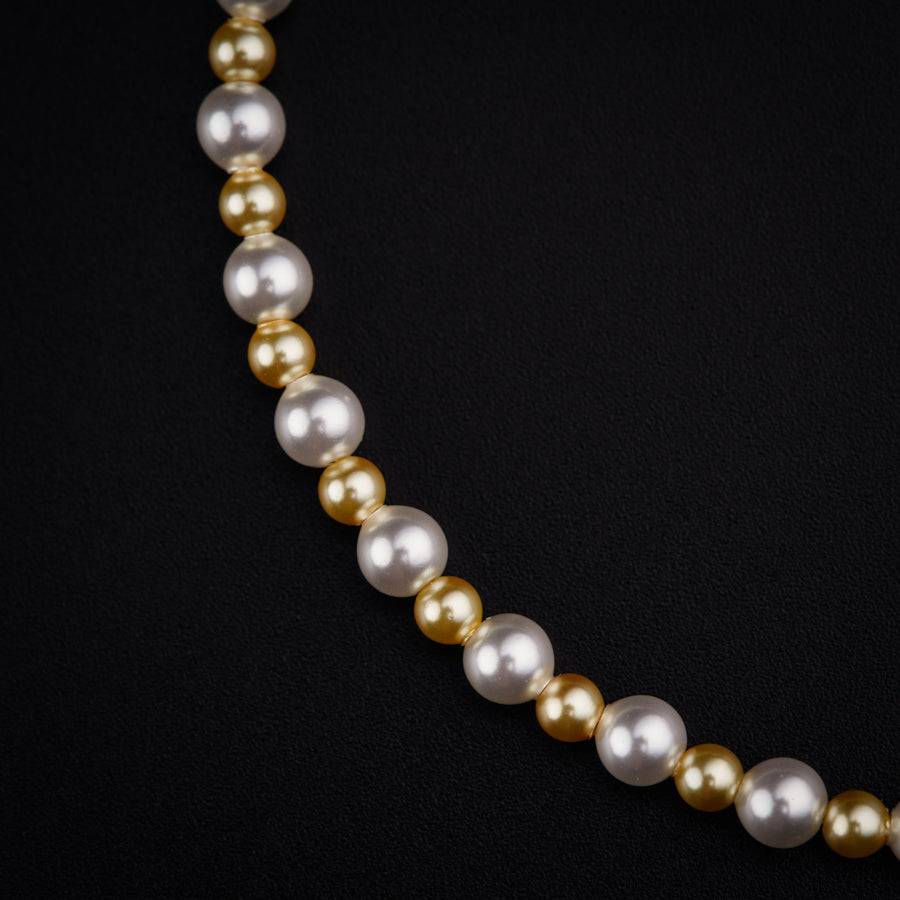 a white and gold necklace on a black background