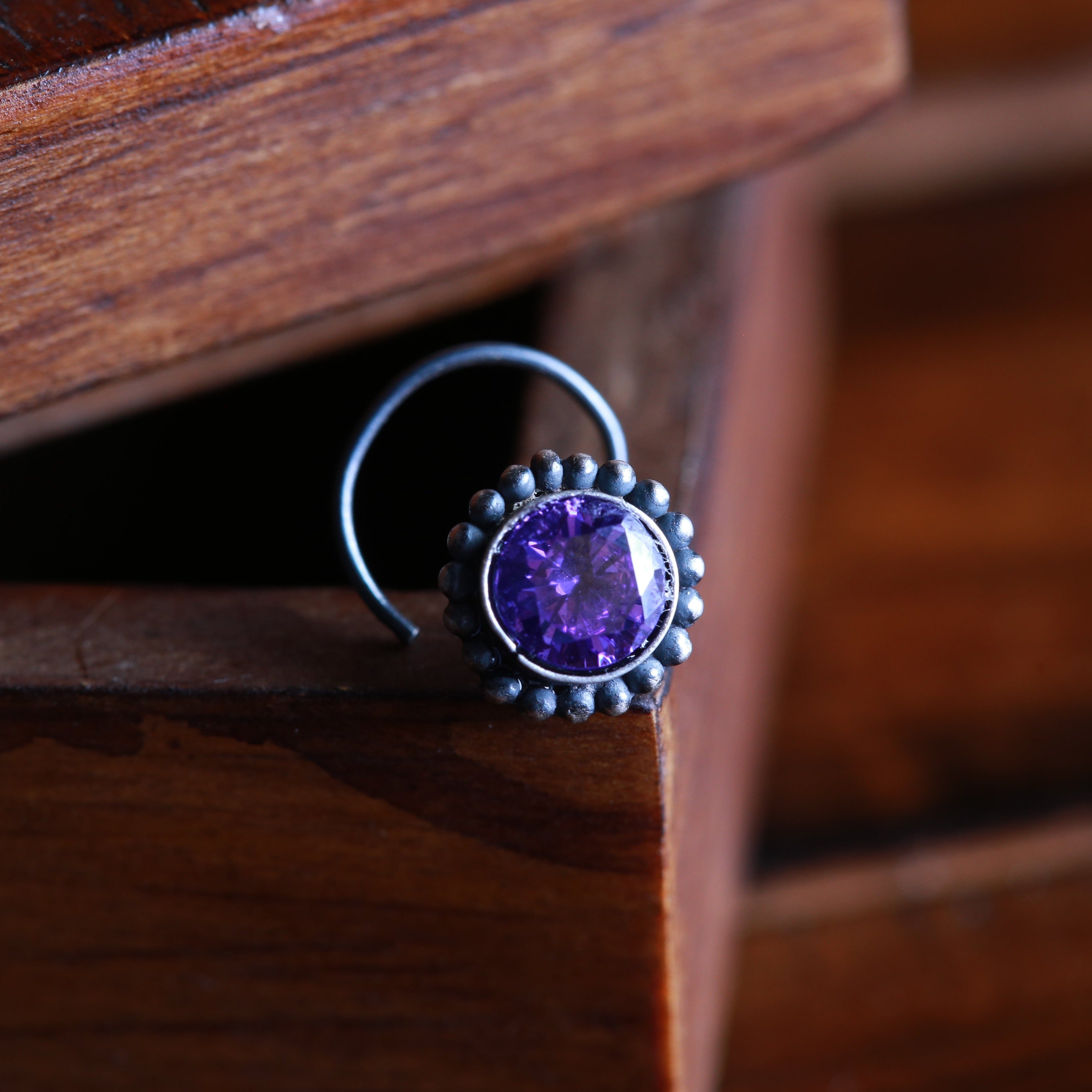 a close up of a ring with a purple stone