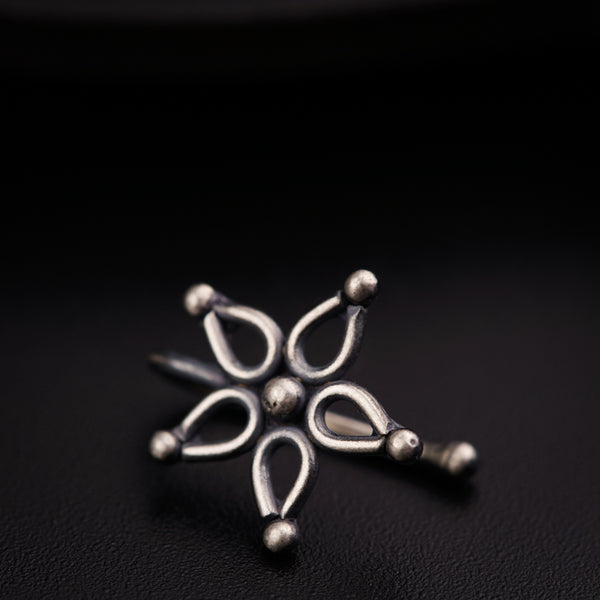 a silver snowflake sitting on top of a black surface