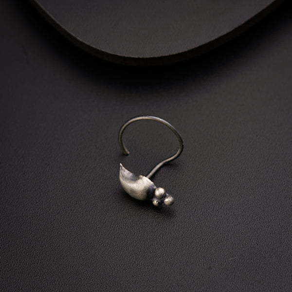 a pair of silver earrings sitting on top of a black surface