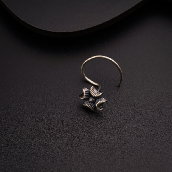 a pair of silver earrings sitting on top of a table