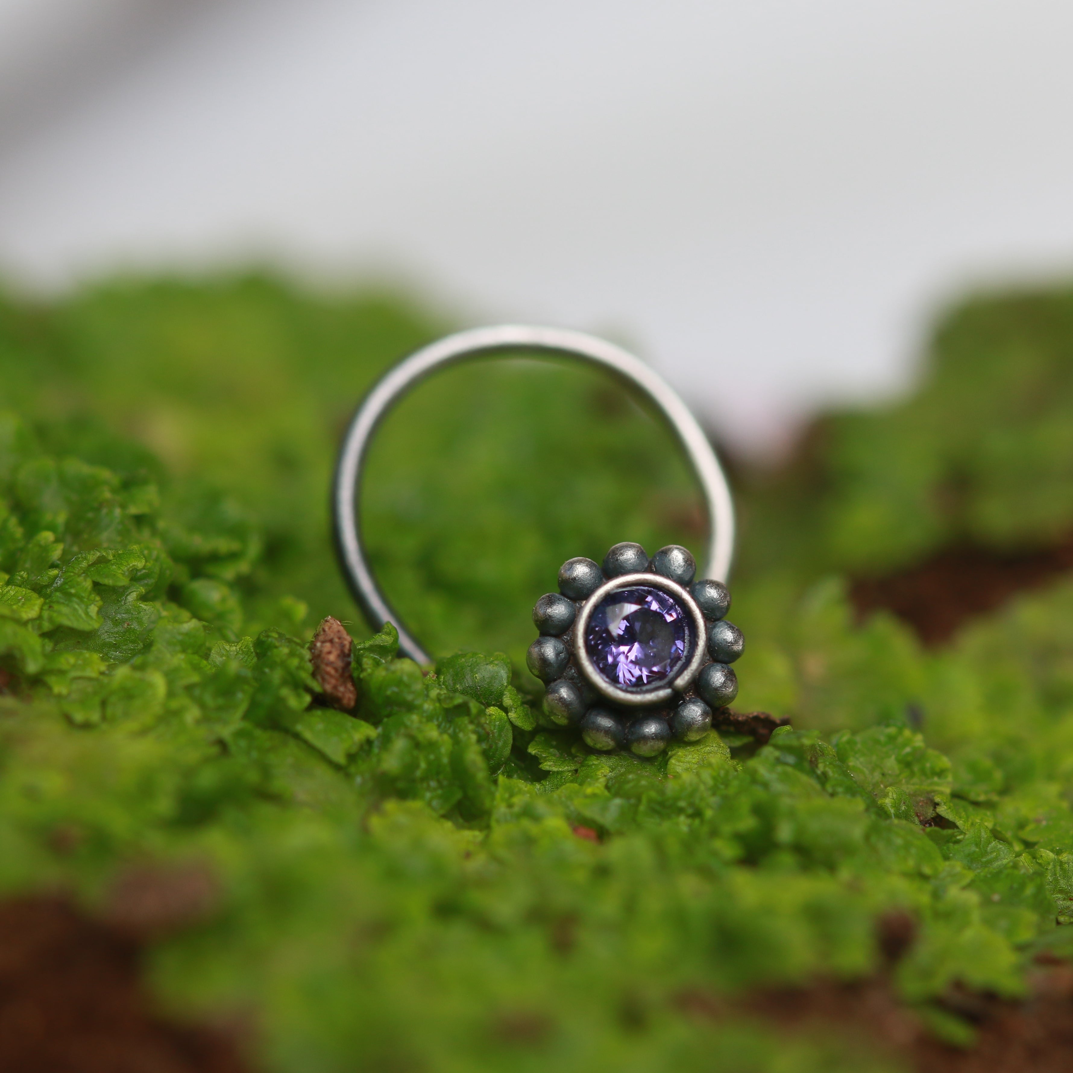 a close up of a ring on a mossy surface
