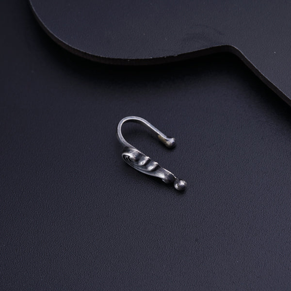 a pair of silver ear clips sitting on top of a guitar