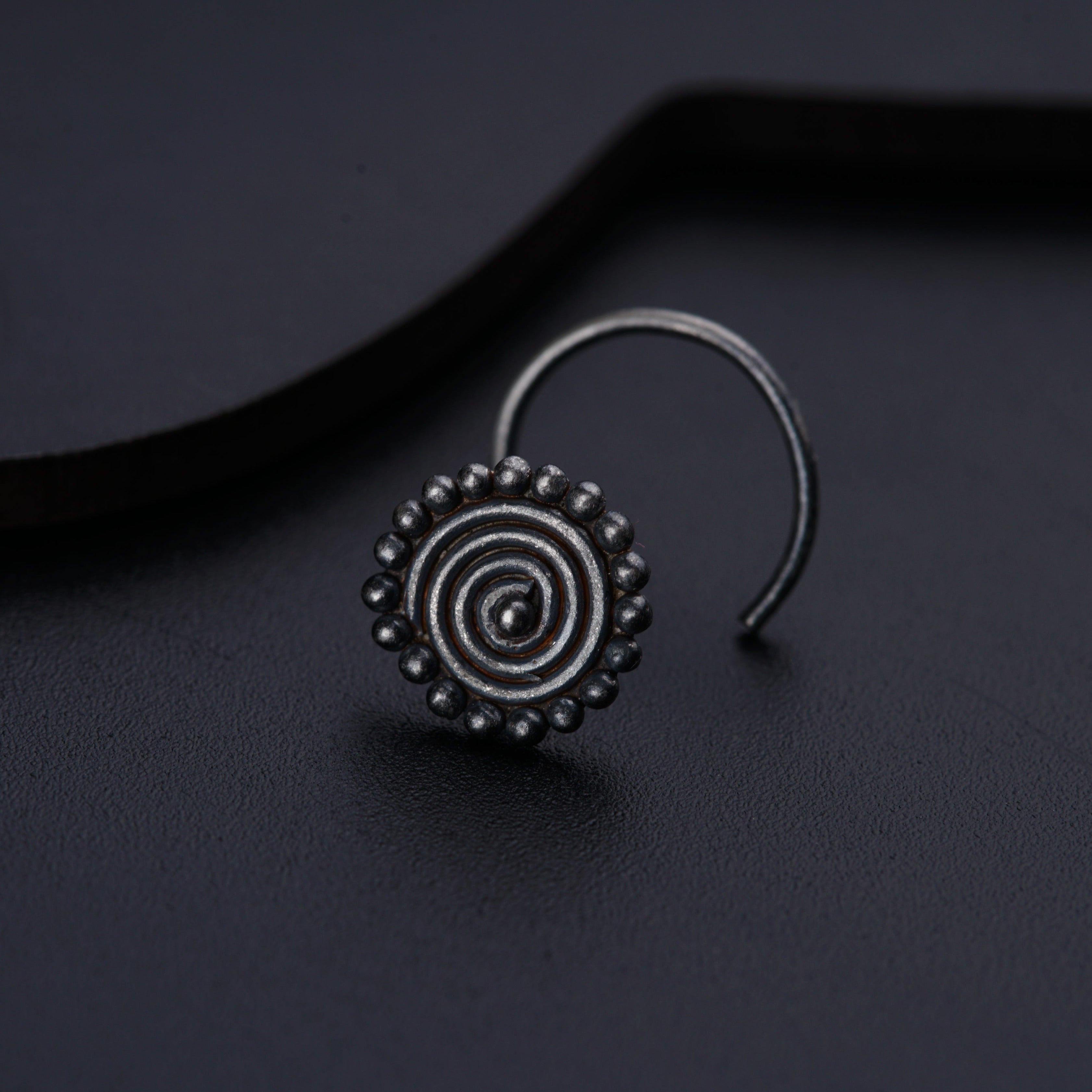 a close up of a pair of earrings on a black surface