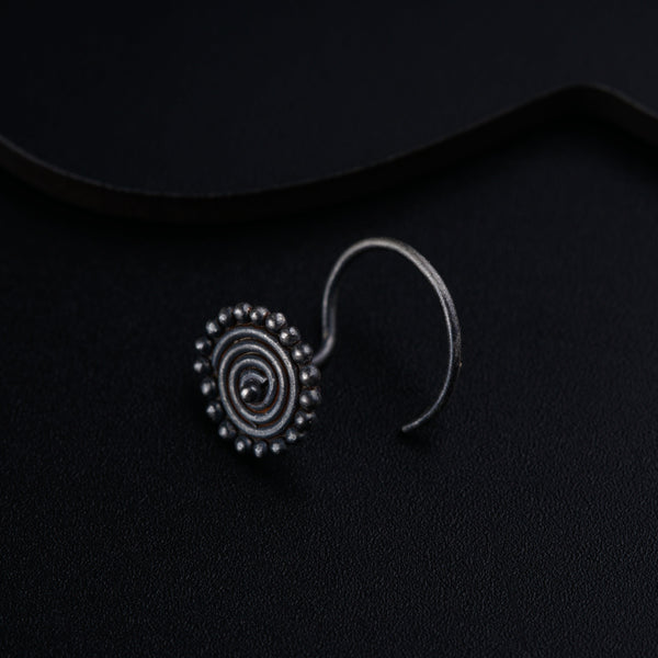 a pair of earrings sitting on top of a black surface