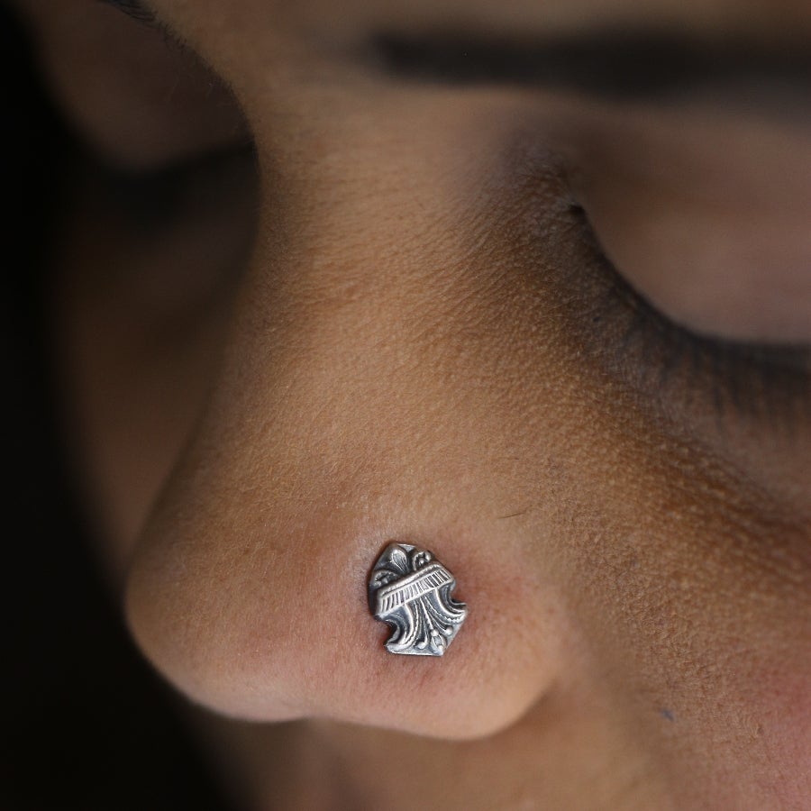 a close up of a person's nose with a silver earring