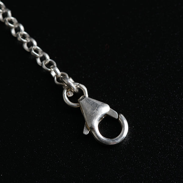 a close up of a metal object on a chain