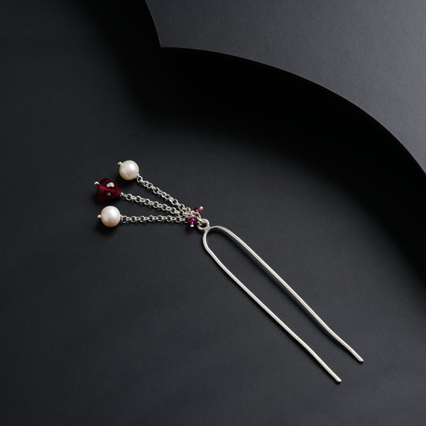 a pair of earrings with pearls hanging from them