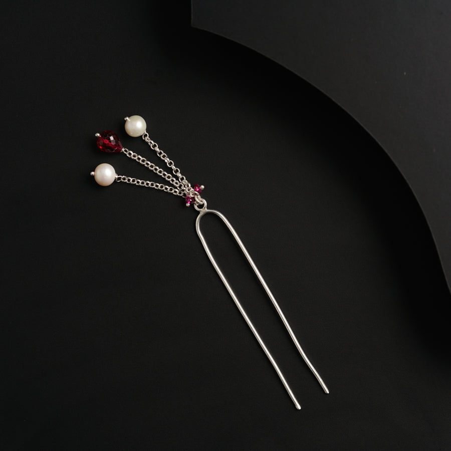 a pair of hair pins with pearls on them