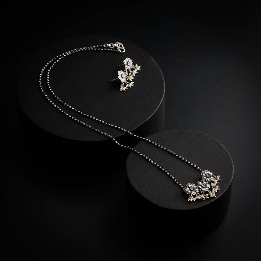 a pair of necklaces sitting on top of a black surface