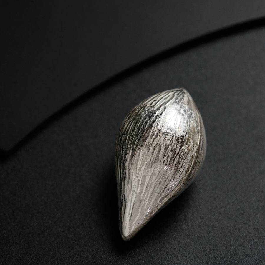 a close up of a silver object on a black surface