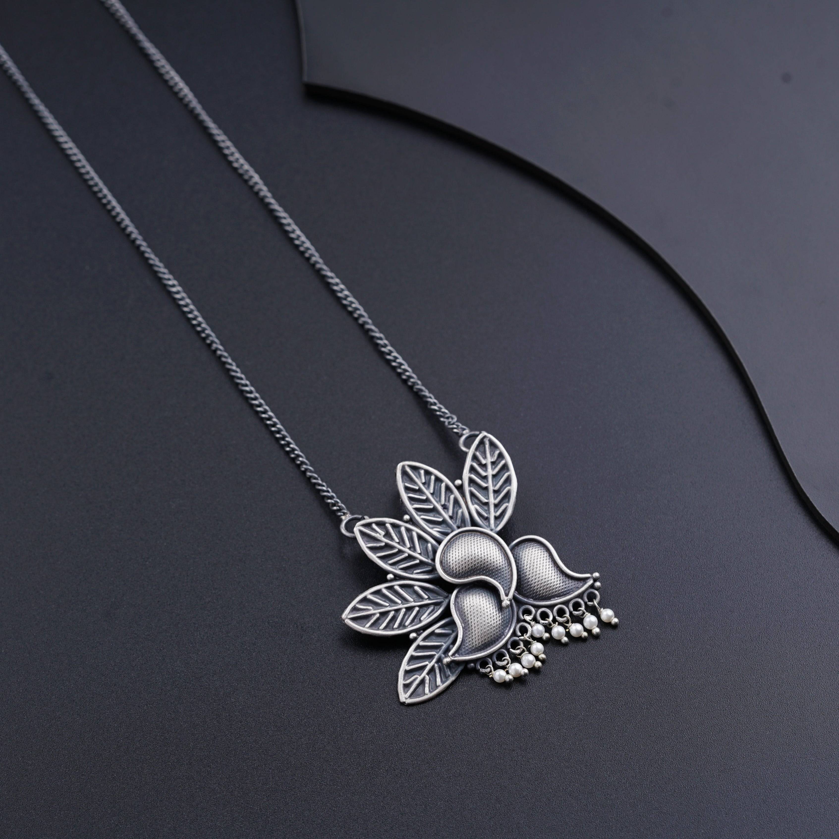 a necklace with a flower and leaves on it