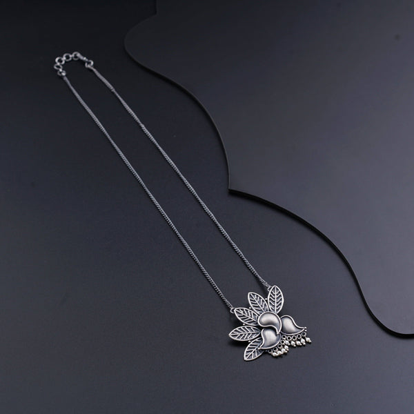 a necklace with a flower and leaves on it
