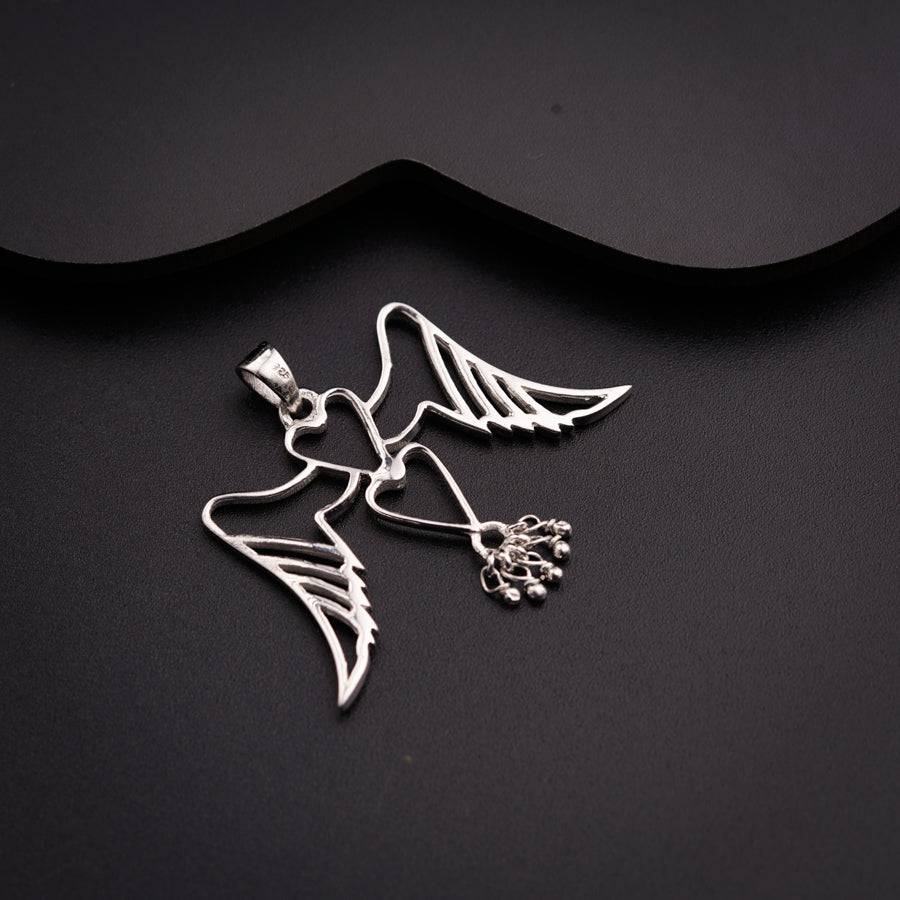 a pair of silver angel charms on a black background