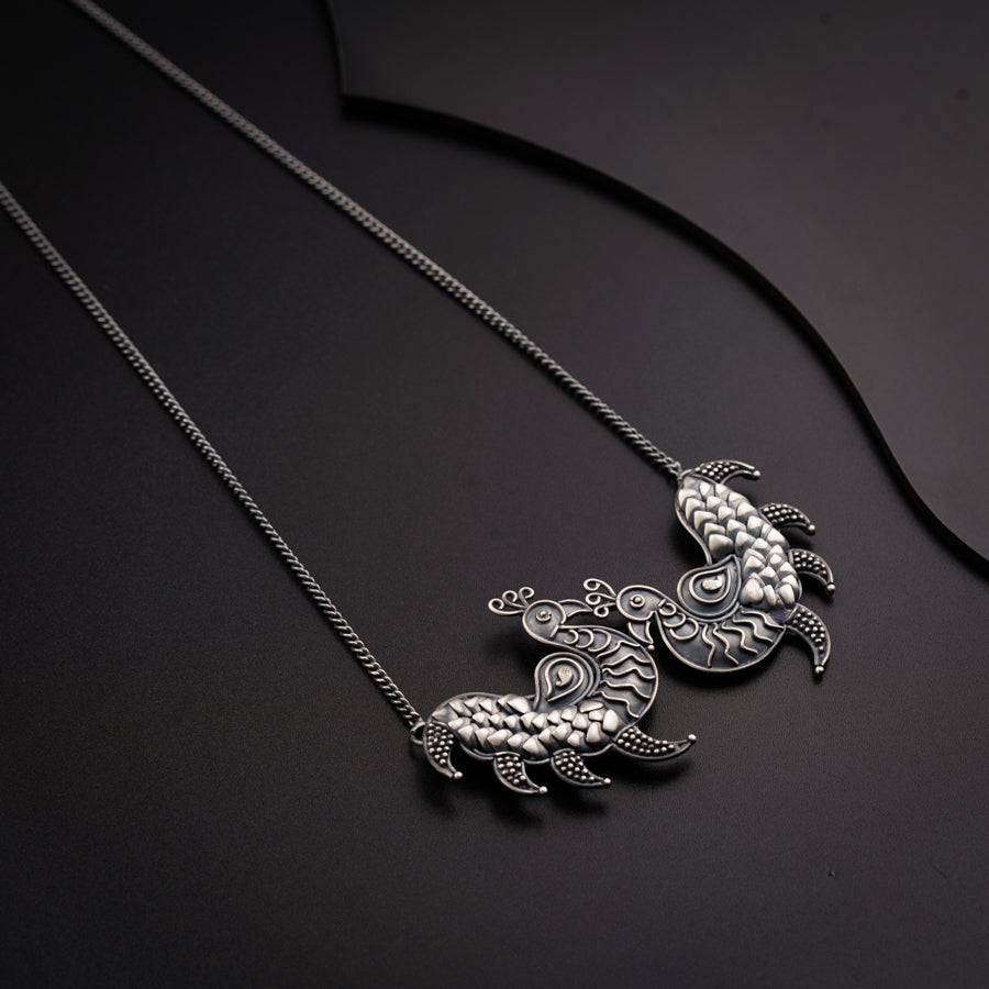 a turtle necklace on a black surface