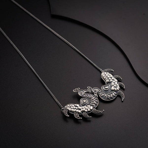 a turtle necklace on a black surface