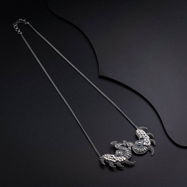 a black and white photo of a necklace on a black surface