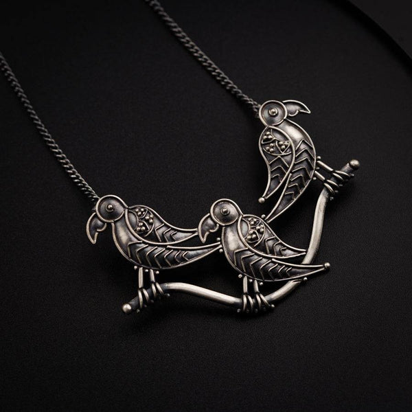 two birds sitting on top of a metal chain