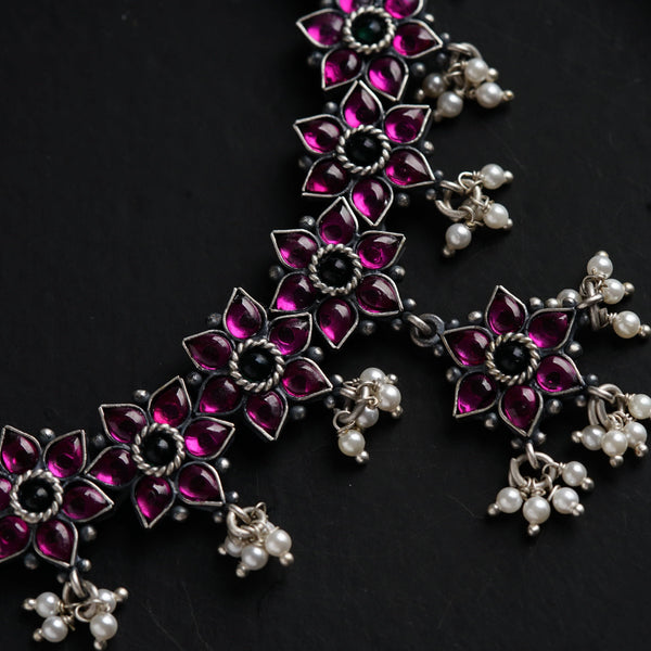 a close up of a necklace on a black surface
