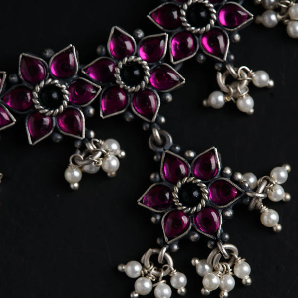 a close up of a necklace on a black surface
