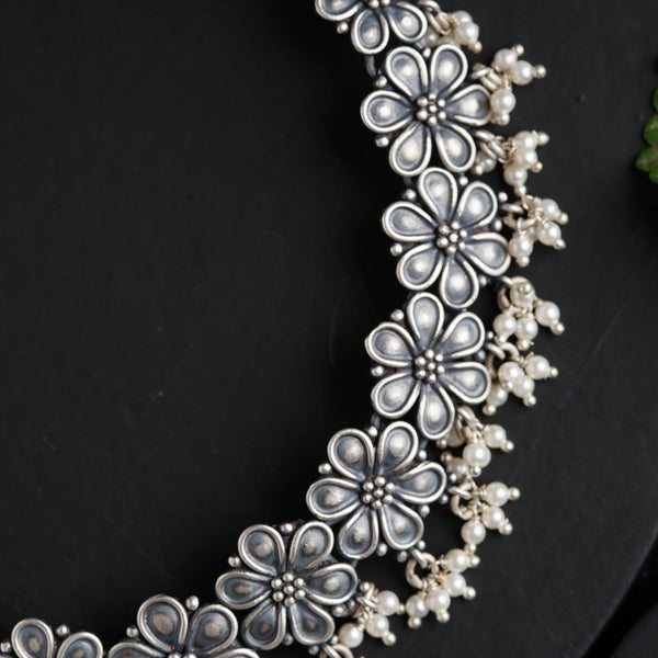 a close up of a necklace on a black surface