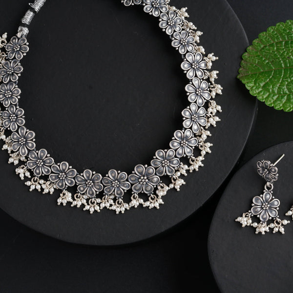a close up of a necklace and earrings on a plate