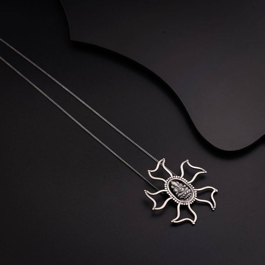 a necklace with a sun design on it