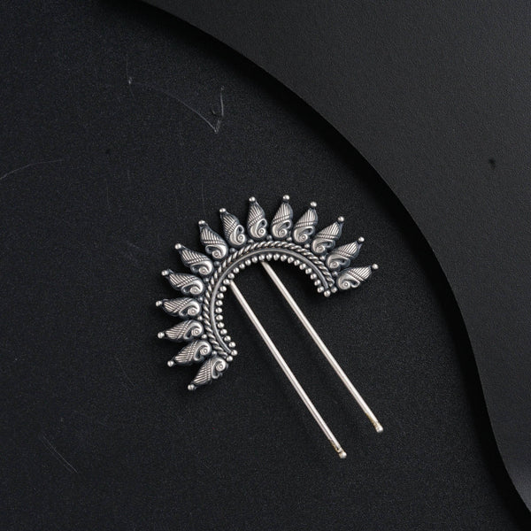 a pair of hair pins sitting on top of a black surface